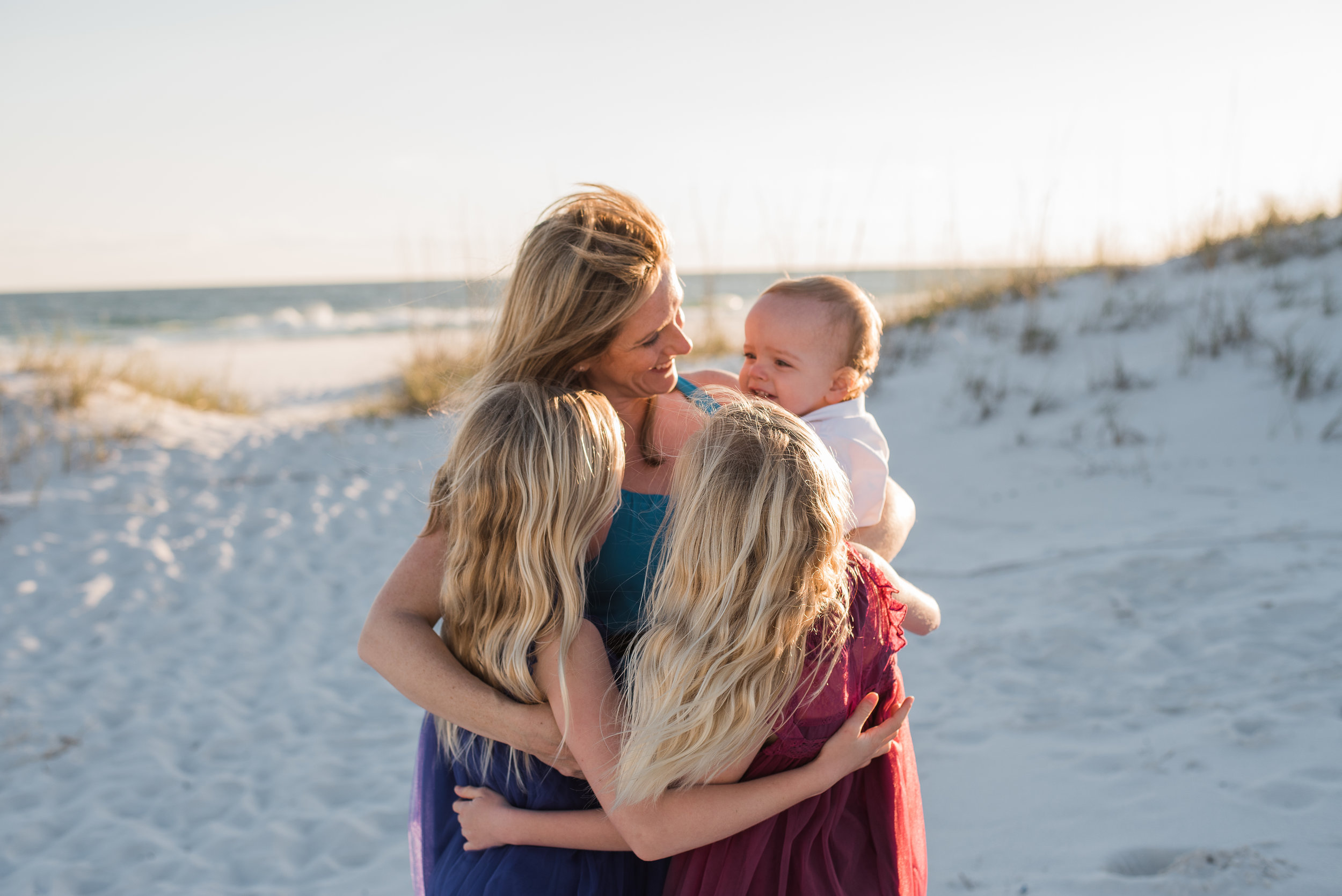 girls hugging mom and mom with baby