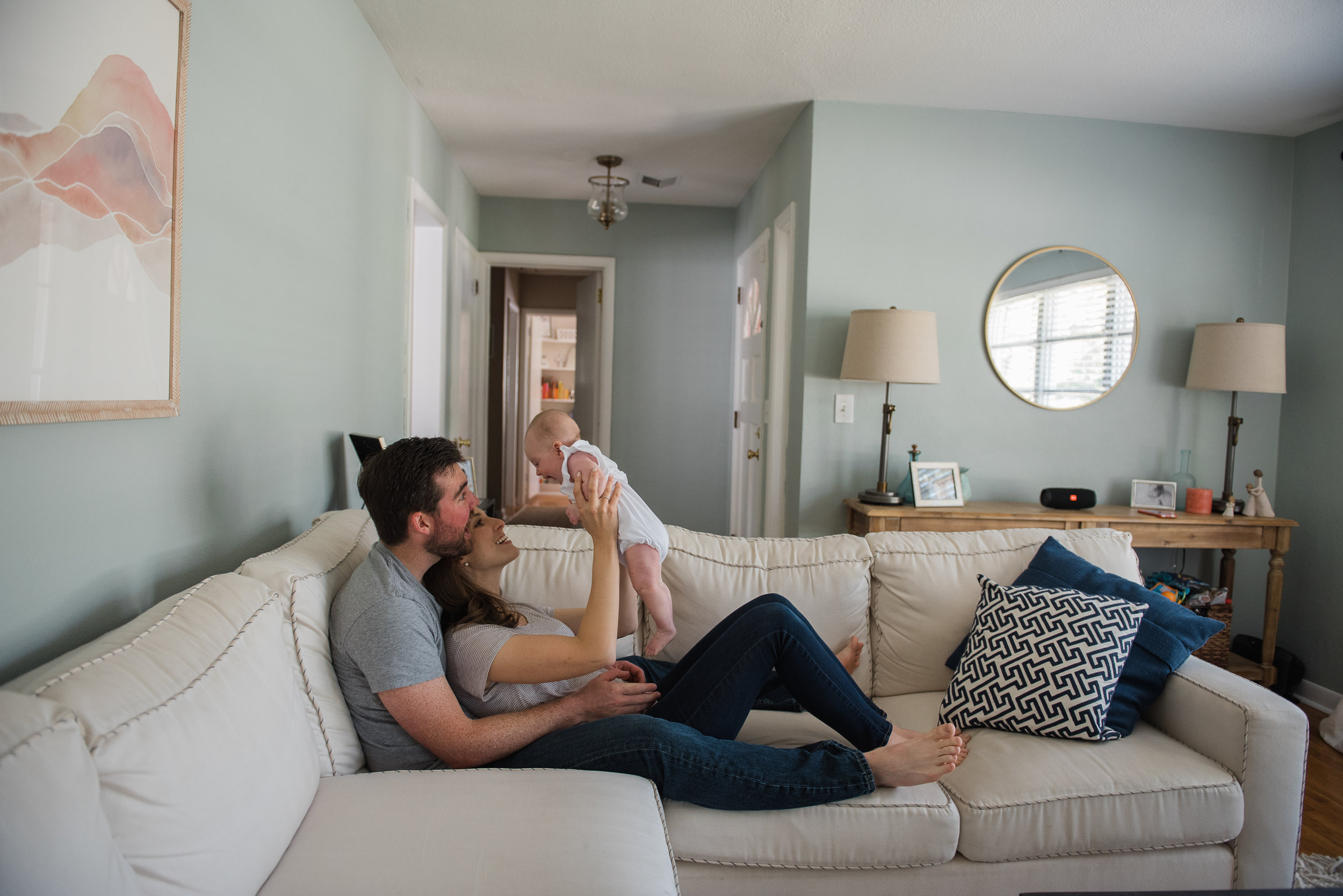 mom and dad in living room with baby-pensacola child photographer