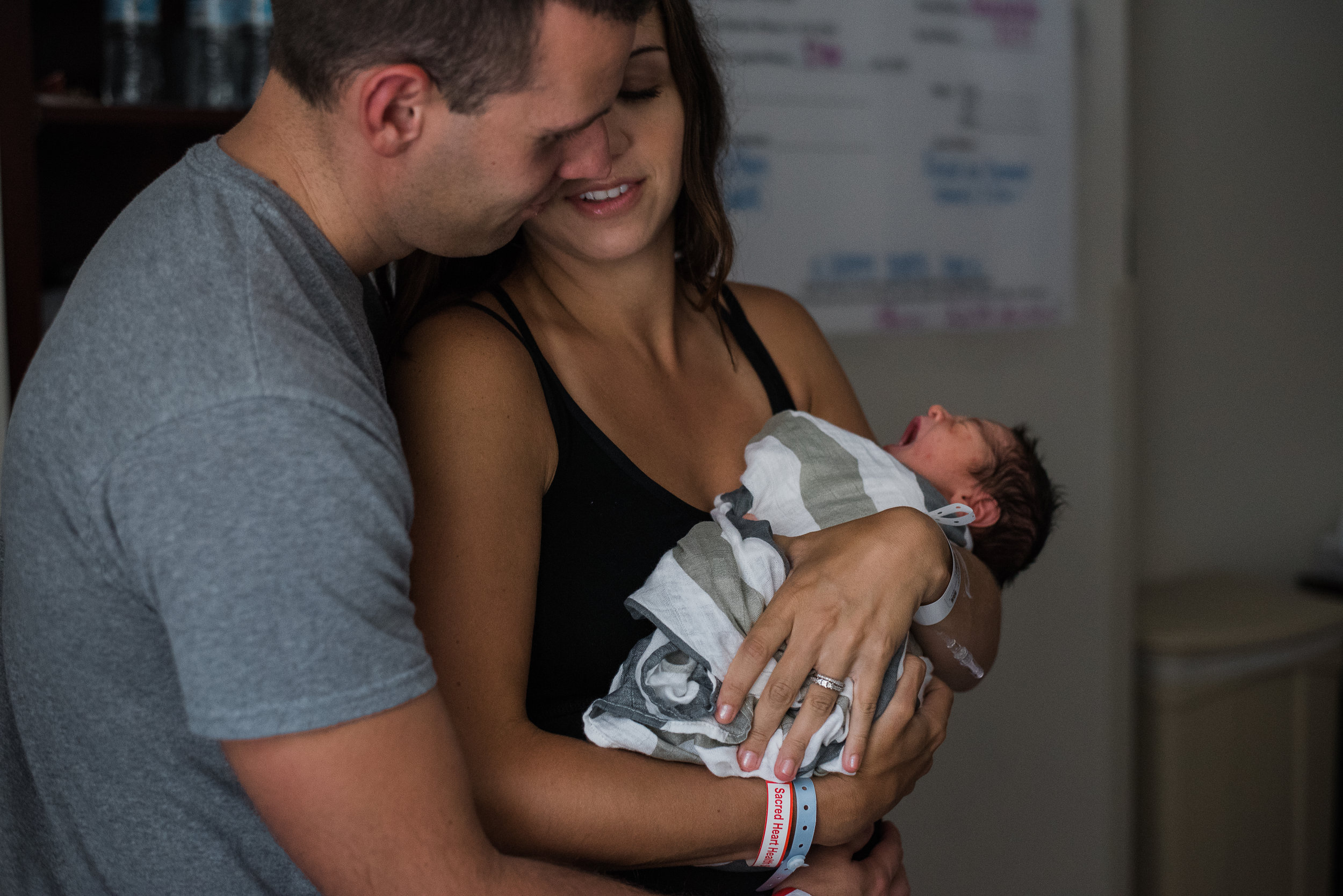 mom and dad holding baby-Pensacola Newborn Photographer