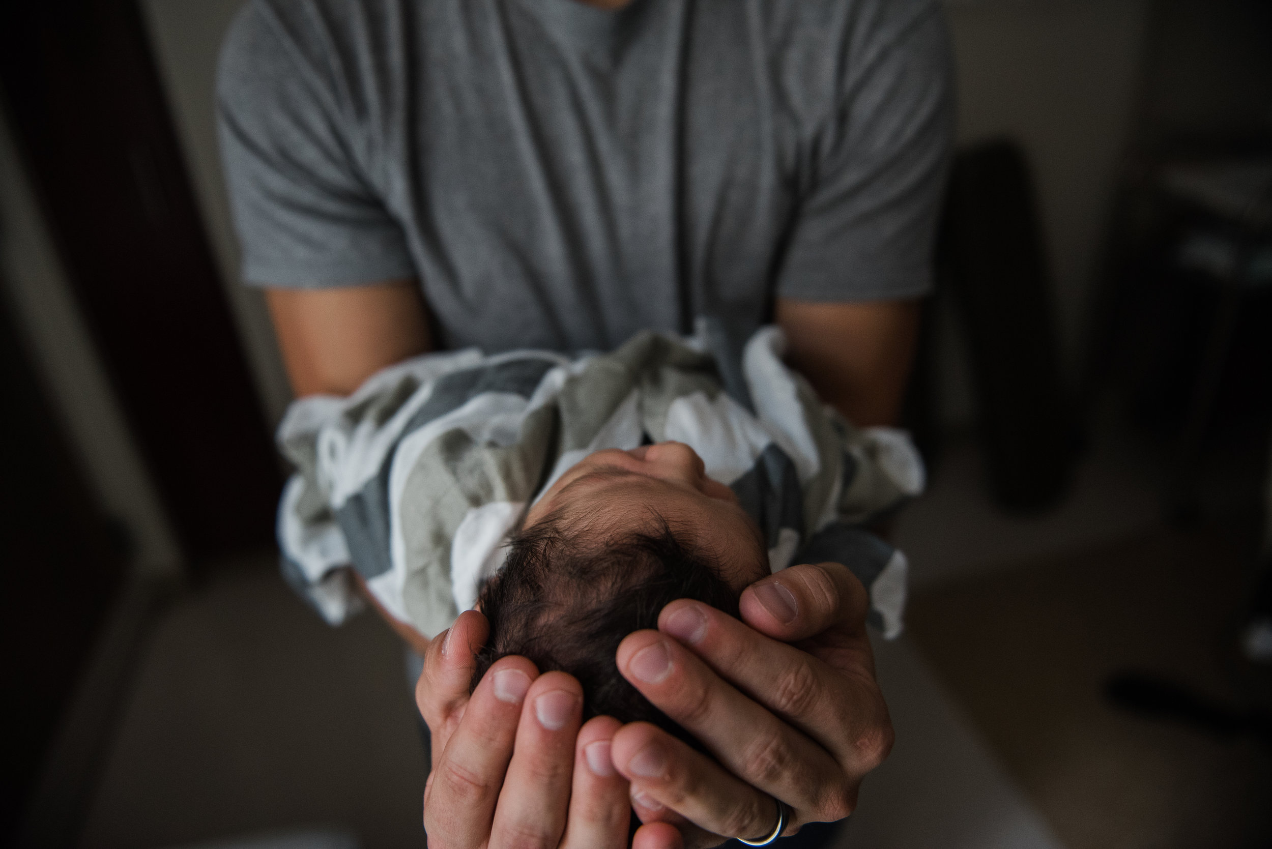 dad with baby head in hands- pensacola newborn photographer