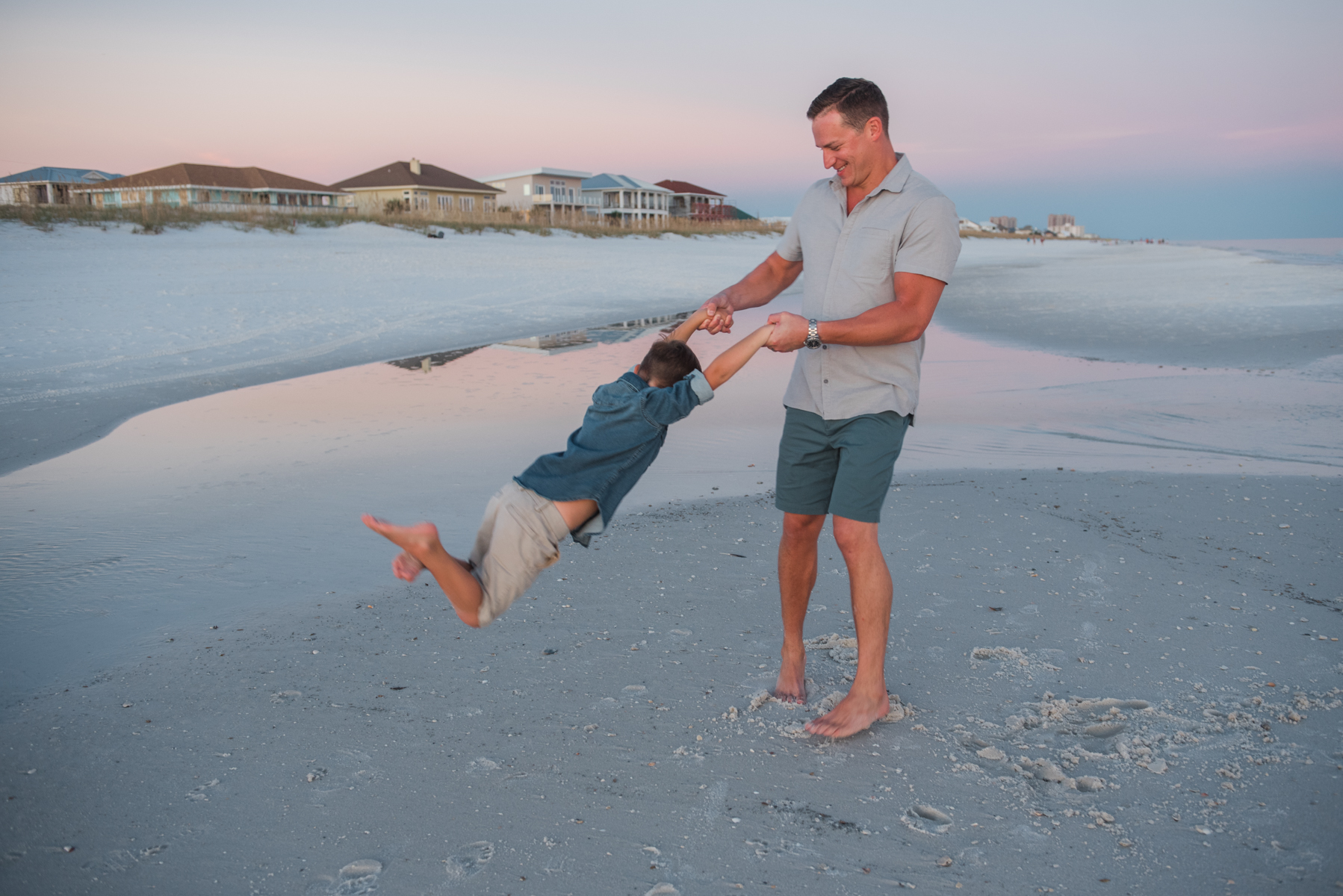dad swinging son at beach-pensacola family photographer