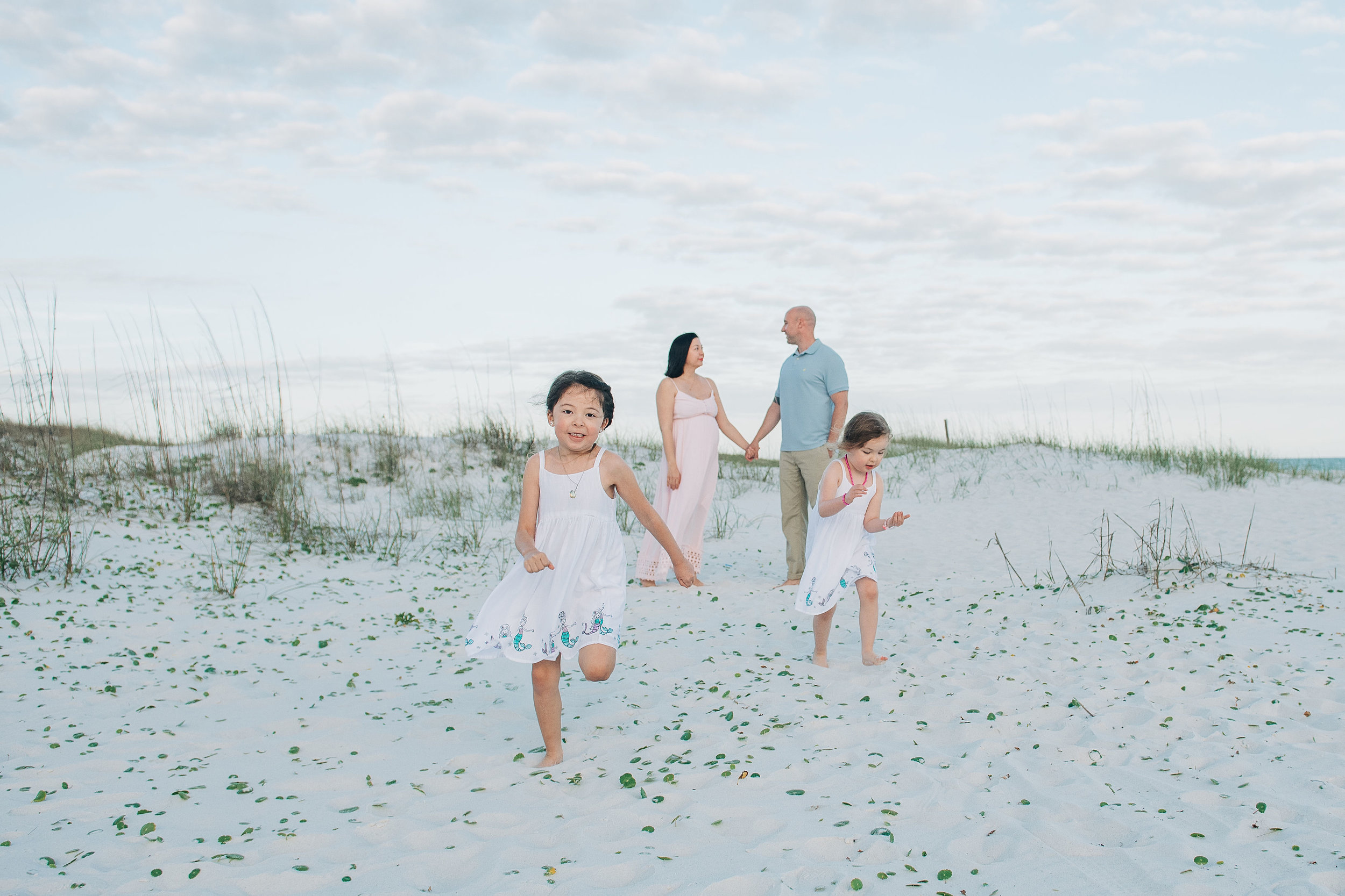 girls running away from mom and dad at Pensacola Beach