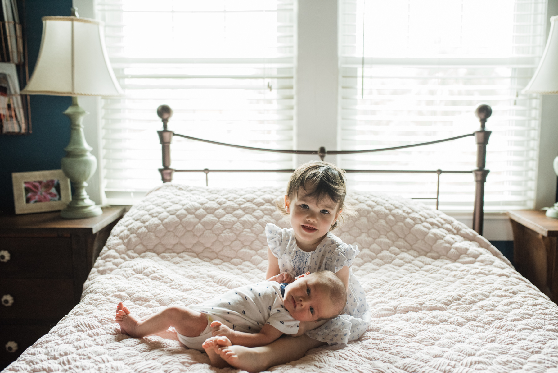 baby holding sister on bed-pensacola newborn photographer