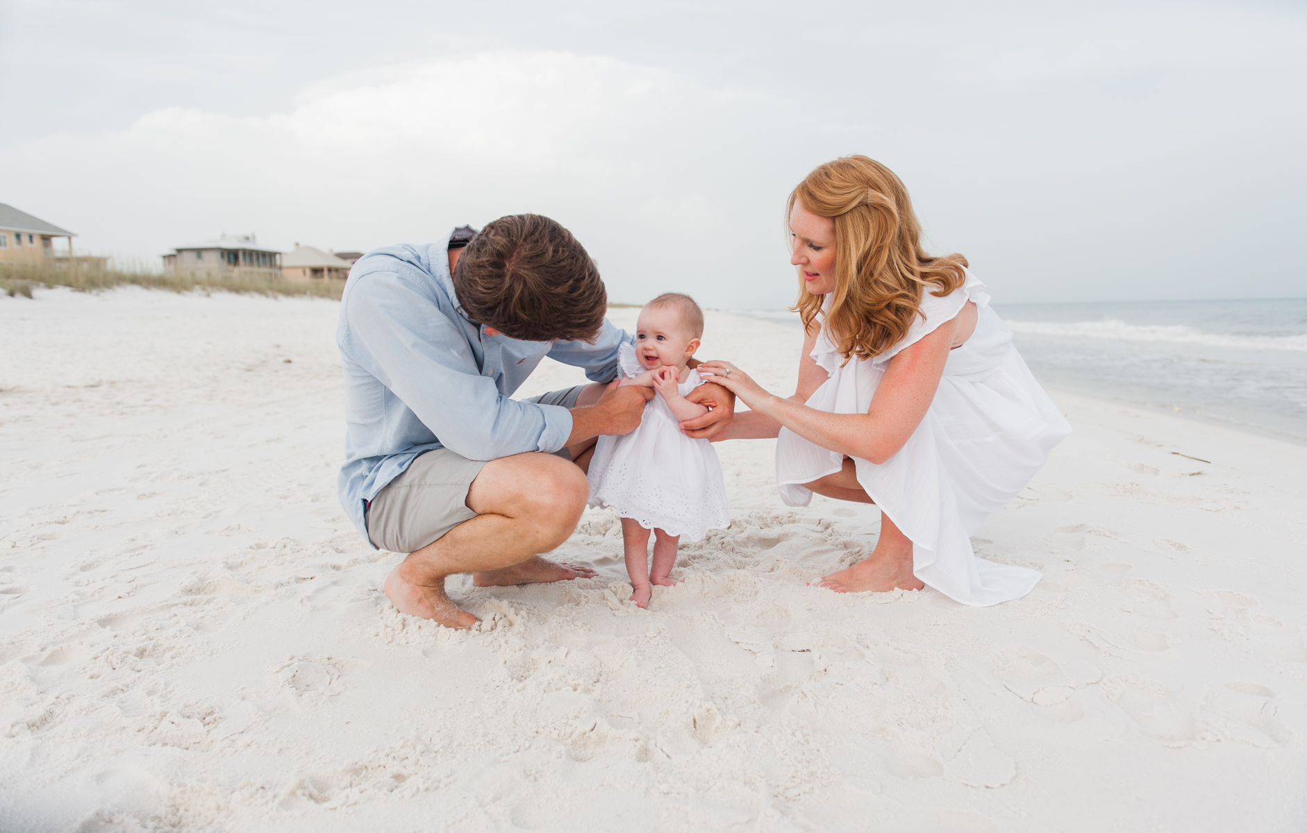 mom and dad with baby in sand-pensacola beach family photographer