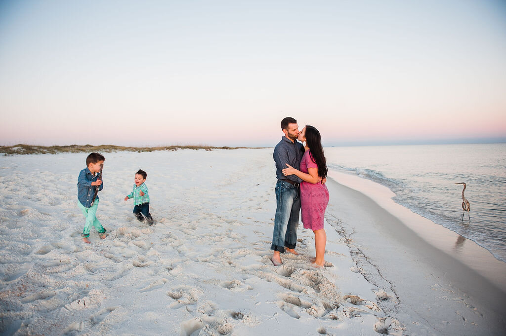 mom and dad kissing on beach-pensacola family photographer