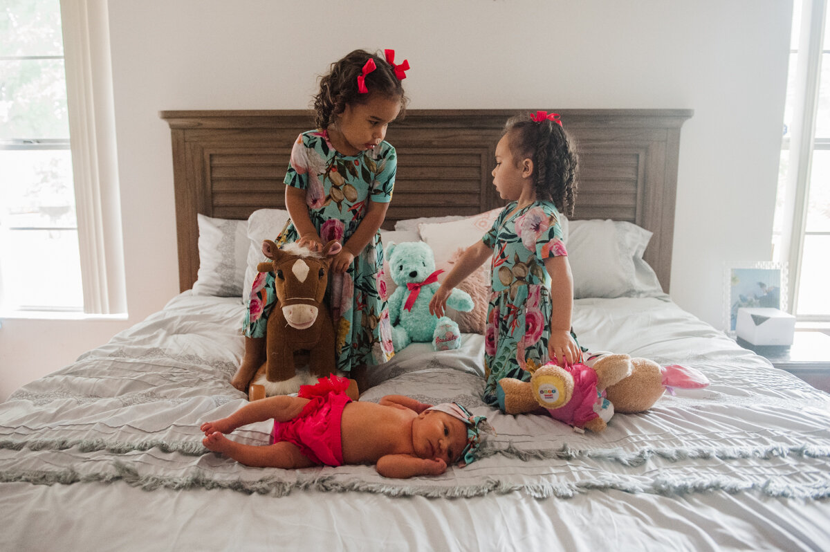 kids on bed with toys and newborn- pensacola newborn photographer