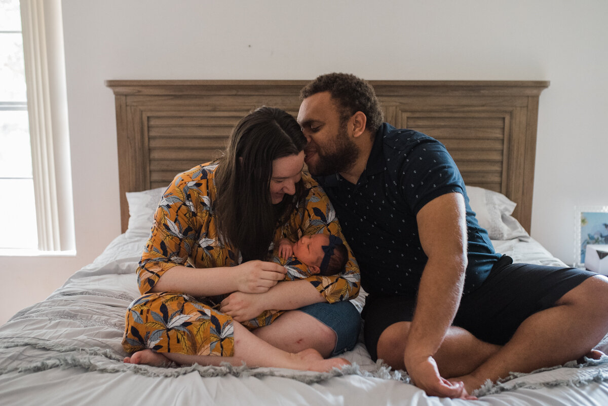 mom and dad kissing baby-pensacola newborn photographer-Ann Mangum Photographer