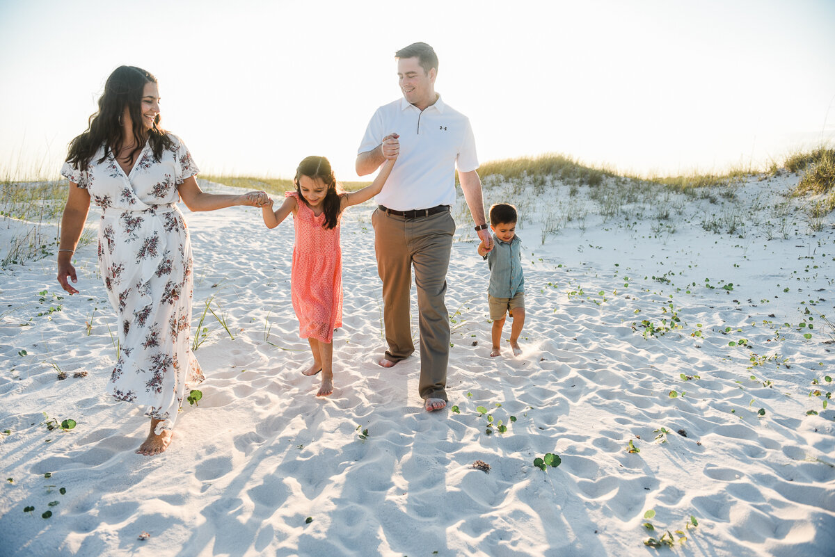 family walking in sand-pensacola family photographer