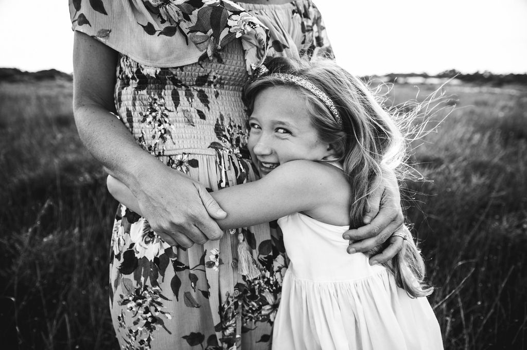girl hugging mom in seagrass-pensacola beach family photographer