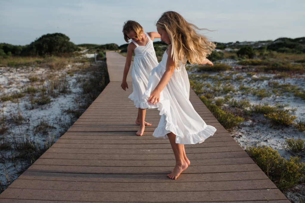 girls twirling on boardwalk at pensacola beach